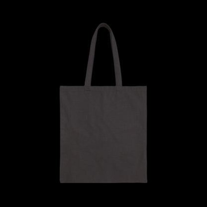 A sleek Cotton Canvas Tote Bag with two shoulder straps stands against a solid black background. This versatile bag, perfect for the conscientious shopper, is crafted from durable fabric and currently sits empty, awaiting your essentials.