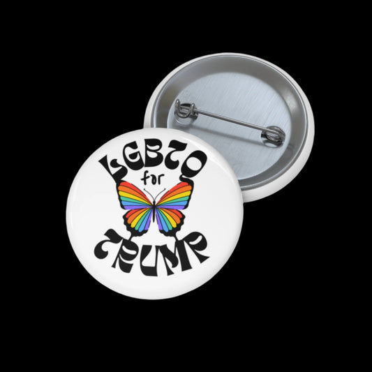 A round LGBTQ for Trump button features a vibrant rainbow butterfly design. It is displayed open, revealing the safety pin backing against a stark black background.