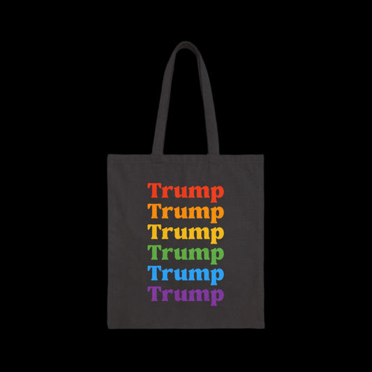 A black tote bag showcasing Trump repeated vertically, each letter in a vibrant rainbow hue of red, orange, yellow, green, blue, and purple. Celebrating pride with colors that echo the spirit of the LGBTQ community—centered and bold.