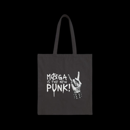 A black canvas tote bag boldly declares MAGA IS THE NEW PUNK! in white, stylized text. Beside it, a graphic of a hand rocking the iconic gesture with a spiked bracelet completes this edgy, must-have punk accessory.