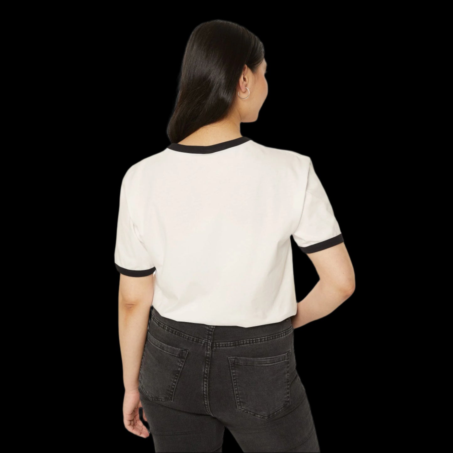 A person with long dark hair stands with their back to the camera, showcasing a retro ringer t-shirt in unisex classic fit. The 100% cotton shirt features black trim on a white canvas, paired effortlessly with dark jeans against a sleek black background.