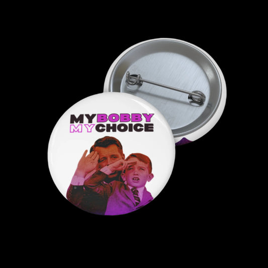 The pin button showcases a vintage-style image of a Bobby Kennedy  and RFK Jr. as a child, with MY BOBBY MY CHOICE boldly above them. Open to reveal its mechanism against a black background, this piece is proudly assembled in the USA.