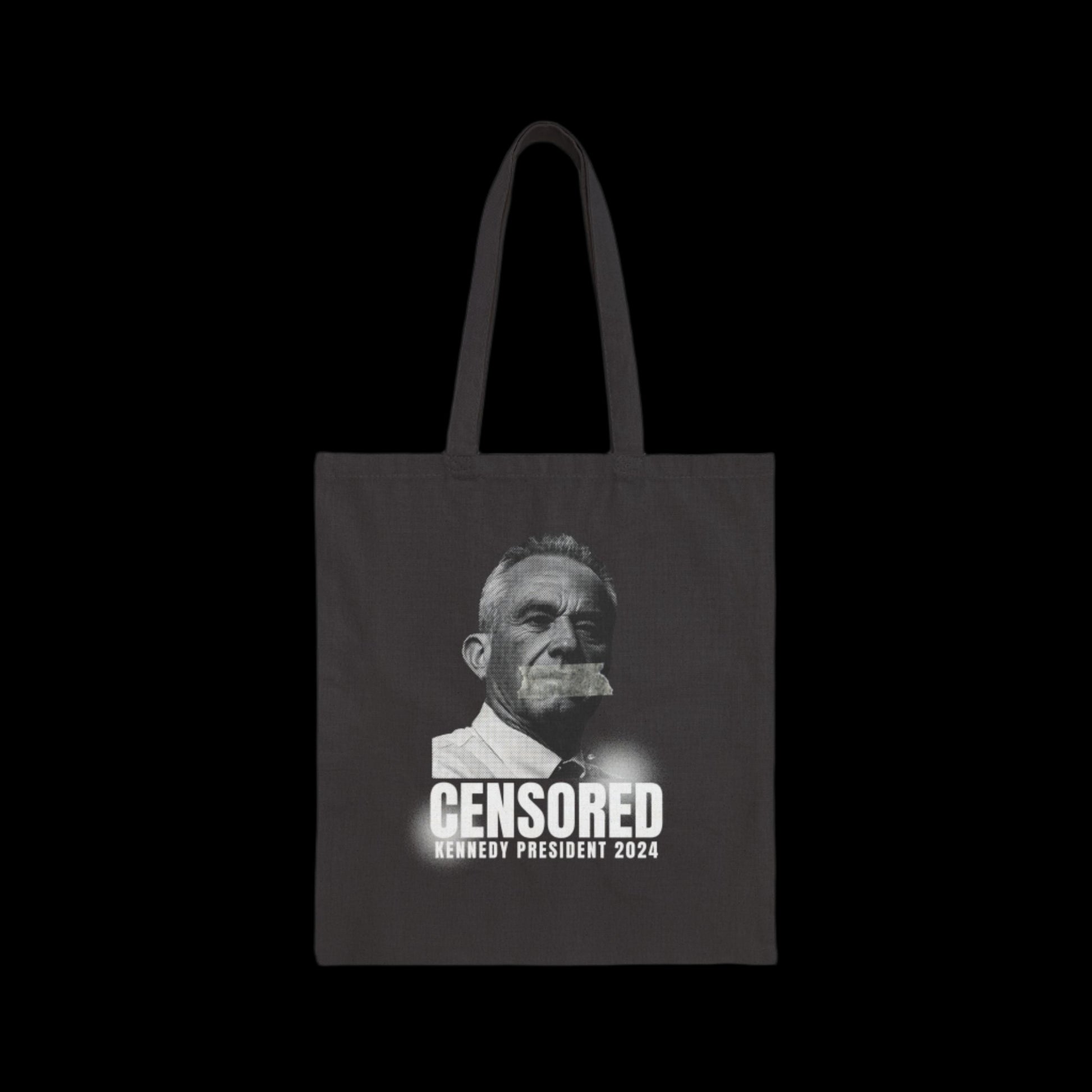 This cotton canvas tote bag showcases a striking image of Robert Kennedy Jr. with tape over his mouth, partially illuminated. Below, the words CENSORED and -Kennedy President 2024 are boldly printed, making a freedom of speech statement in style.