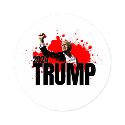 A graphic featuring Donald J. Trump raising his fist, wearing a suit with a red tie, against a splattered red background. The text 2024 TRUMP is boldly printed below, making it the perfect premium vinyl sticker for supporters.