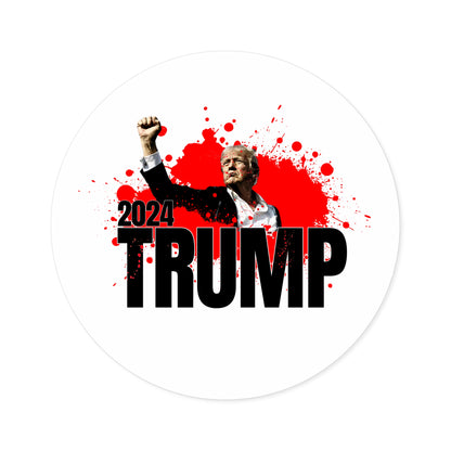 A graphic featuring an illustration of Donald Trump raising a fist, accented with red splatters. The bold black text 2024 TRUMP stands prominent, reminiscent of the assassination attempt of Donald Trump