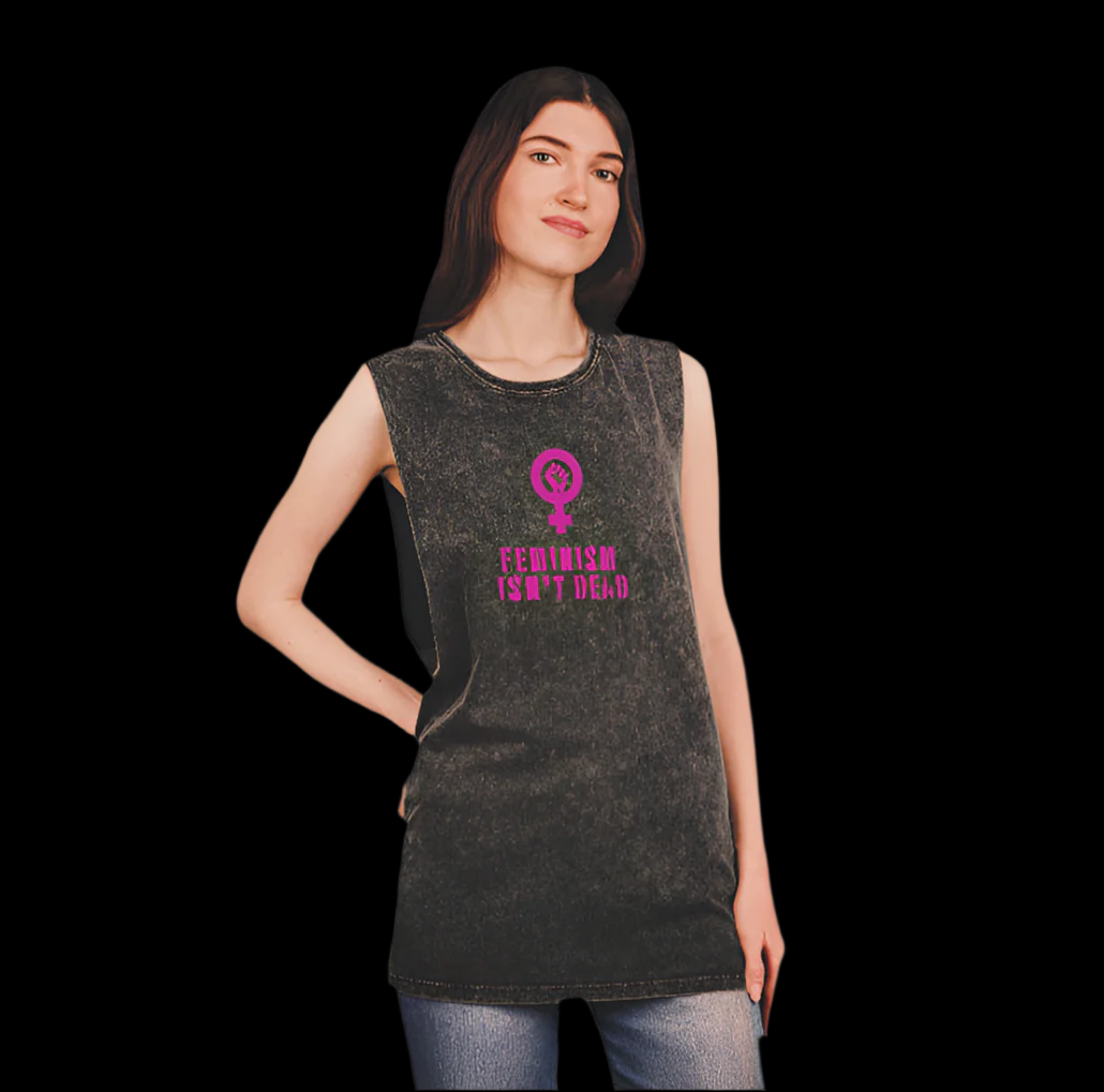 A woman wears a vintage tank top with Feminism Isnt Dead in bold pink letters and a feminist symbol. Against a black background, she stands confidently with one hand on her hip, looking slightly up and to the side, embodying the spirit of women’s rights.